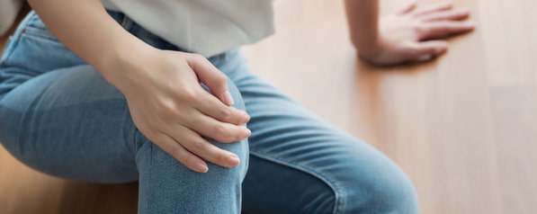Injured woman on the ground holding her knee following a slip and fall accident
