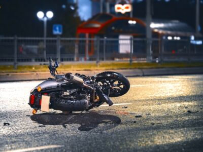 Motorcycle involved in collision lying on the roadway at night.