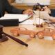 Wooden cars with judge’s gavel on lawyer’s table during meeting