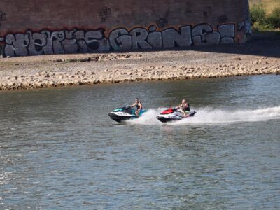 Two people riding jet skis on a river
