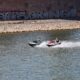 Two people riding jet skis on a river